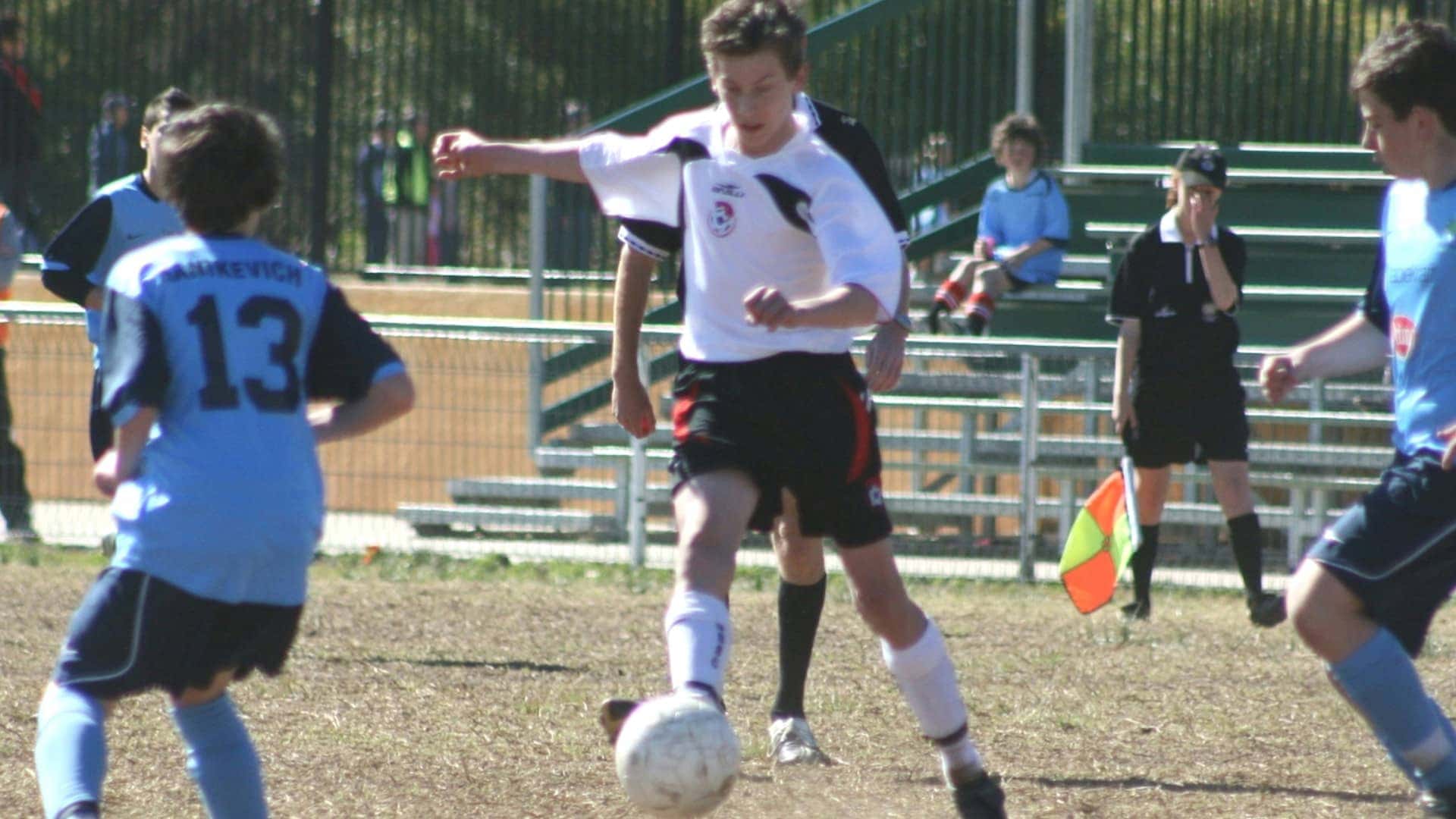 Former student dribbling the ball between defenders