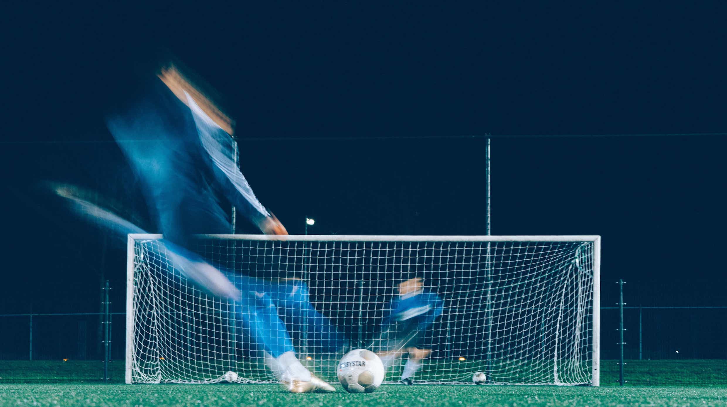 Blurred time lapse image of a striker taking a penalty spot kick