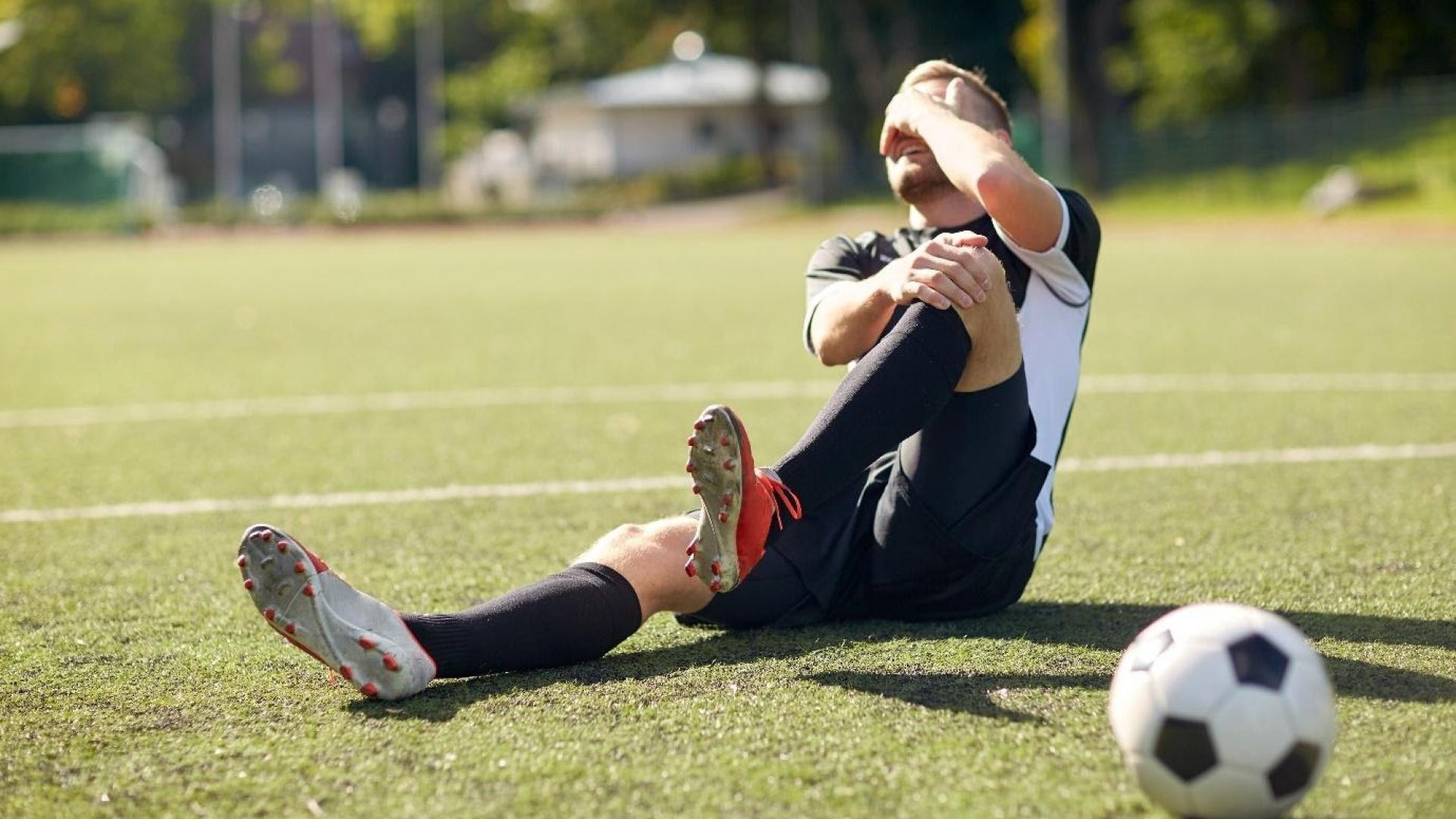 Male football player reacting to knee injury