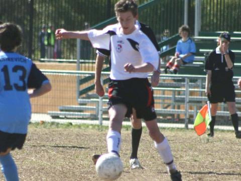 Former student dribbling the ball between defenders